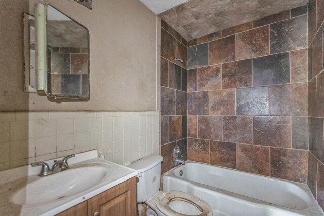 full bathroom featuring tile walls, vanity, toilet, and shower / bath combination