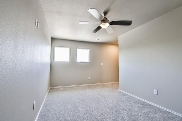 empty room with ceiling fan and light carpet