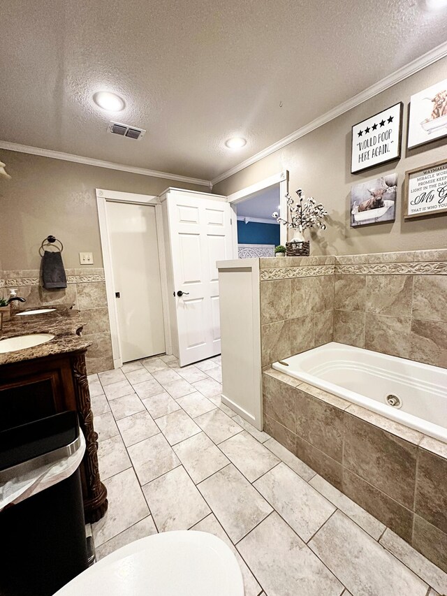 5712 70th Pl, Lubbock, TX 79424 - bathroom with a textured ceiling, ornamental molding, a whirlpool tub, vanity, and tile walls