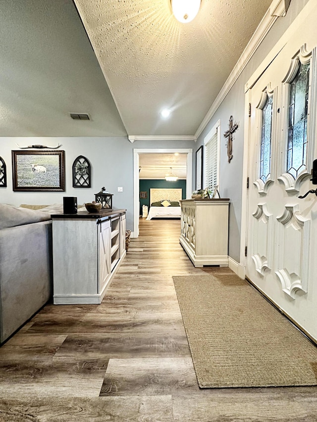 5712 70th Pl, Lubbock, TX 79424 - corridor featuring a textured ceiling, crown molding, wood finished floors, and healthy amount of natural light