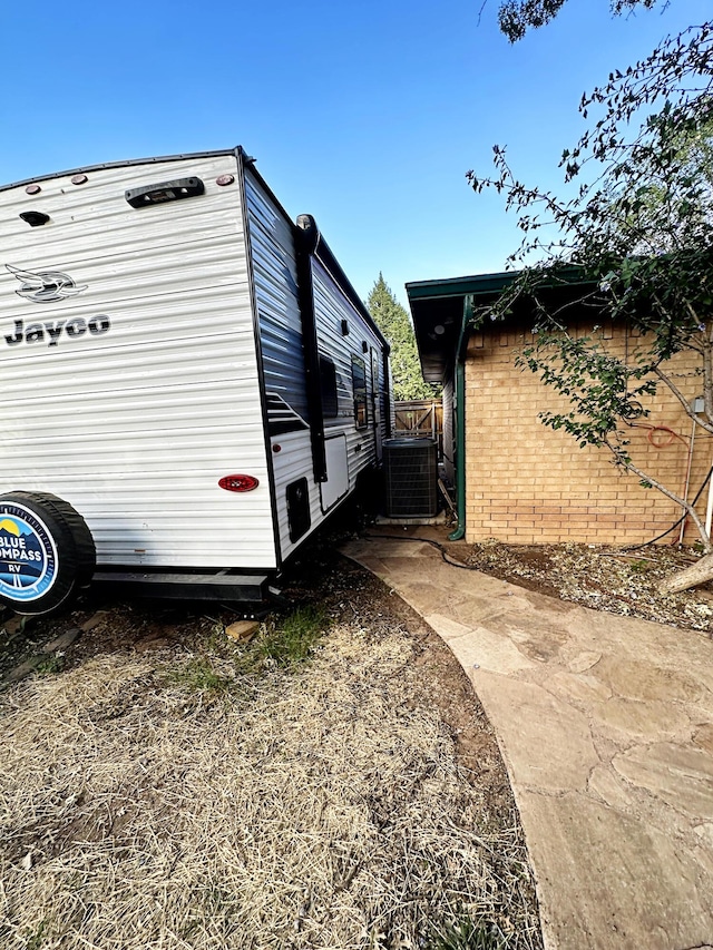 5712 70th Pl, Lubbock, TX 79424 - view of side of property with brick siding and a cooling unit