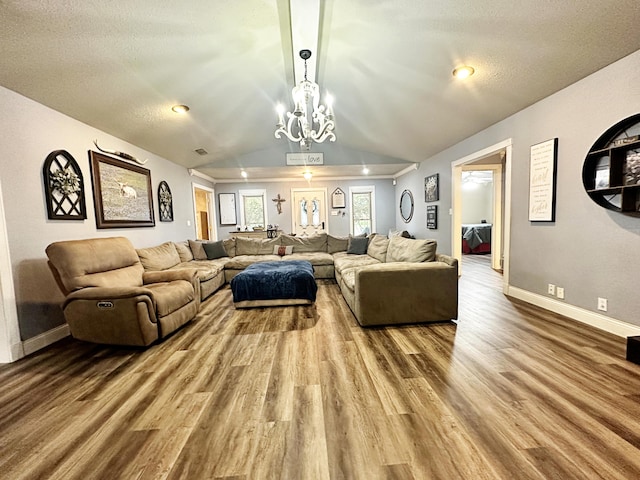 5712 70th Pl, Lubbock, TX 79424 - living room featuring wood finished floors, lofted ceiling, and a chandelier
