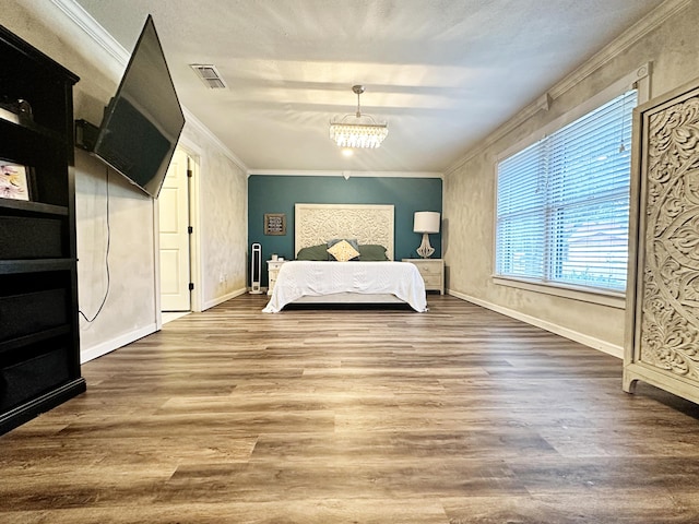5712 70th Pl, Lubbock, TX 79424 - bedroom featuring ornamental molding, wood finished floors, and a chandelier
