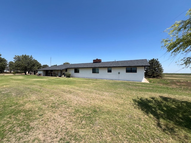 rear view of property featuring a lawn