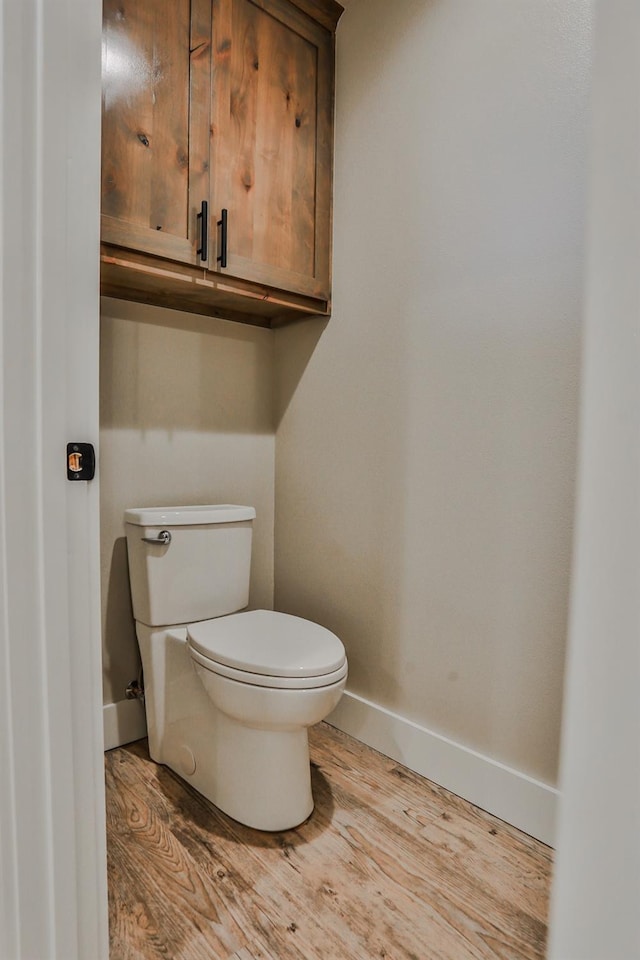 bathroom with wood-type flooring and toilet