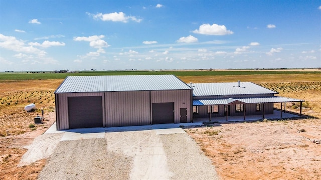 view of front of property with a garage and a rural view