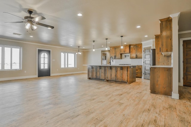 kitchen featuring pendant lighting, tasteful backsplash, a spacious island, and light wood-type flooring