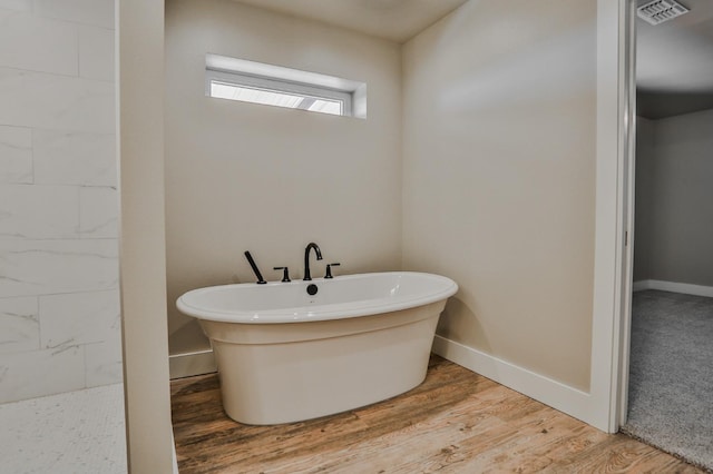 bathroom featuring a bath and wood-type flooring