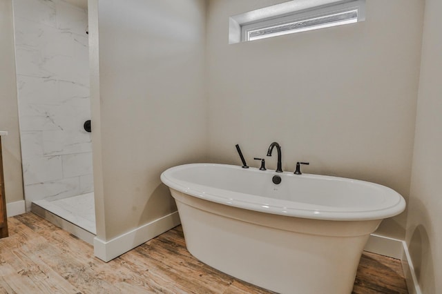 bathroom featuring hardwood / wood-style flooring and plus walk in shower