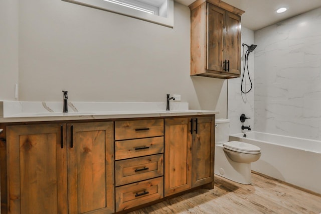 full bathroom with tiled shower / bath, vanity, toilet, and hardwood / wood-style floors