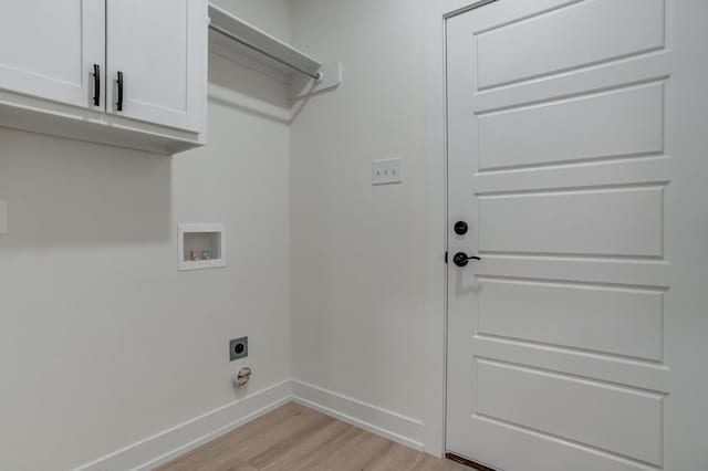 laundry area with electric dryer hookup, hookup for a washing machine, cabinets, and light wood-type flooring