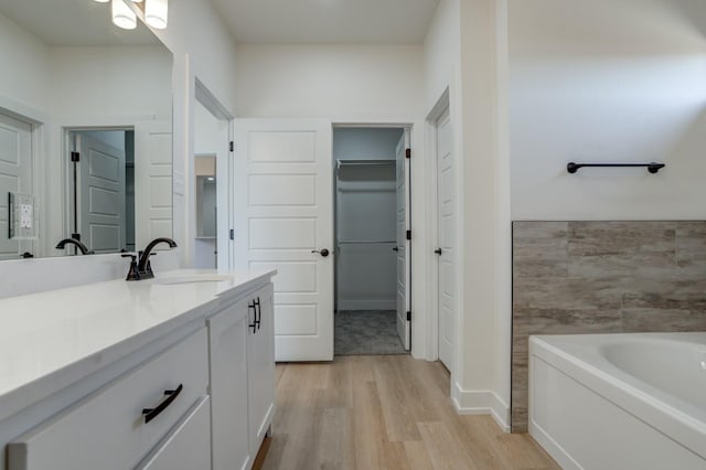 bathroom featuring wood-type flooring, a tub, and vanity