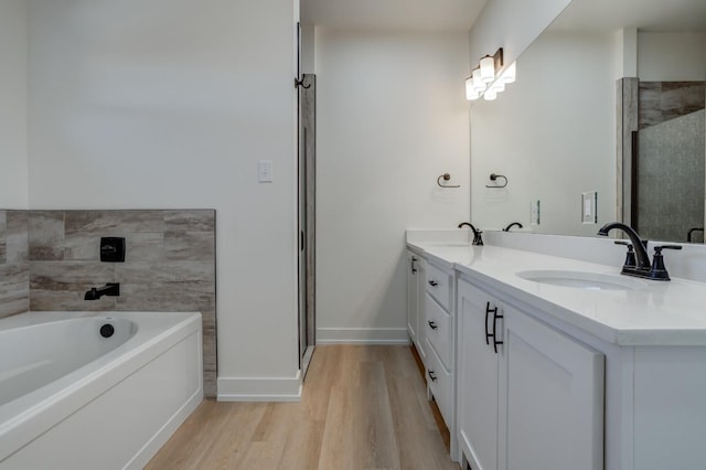 bathroom with hardwood / wood-style flooring, vanity, and a bathtub