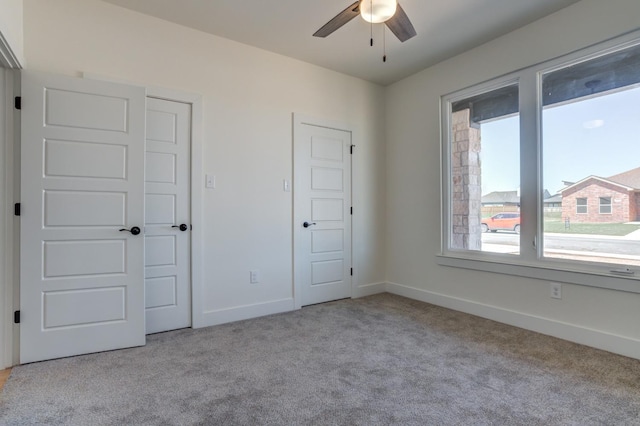 unfurnished bedroom featuring light colored carpet and ceiling fan