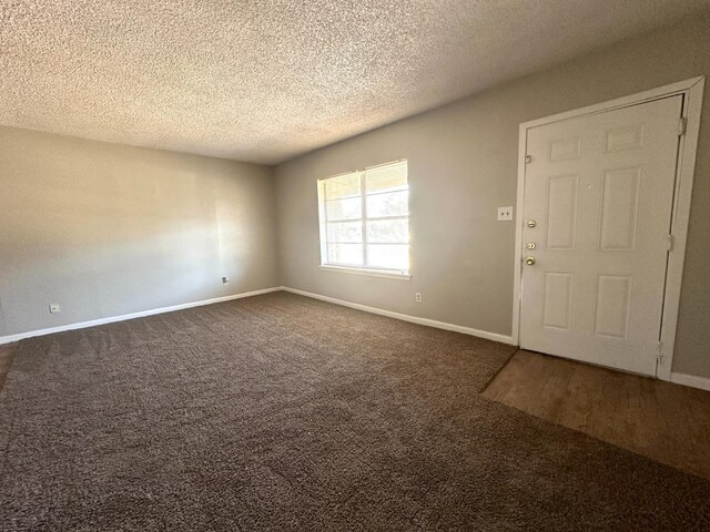 carpeted spare room featuring a textured ceiling