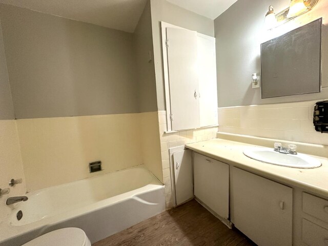 bathroom featuring hardwood / wood-style flooring, vanity, a bathtub, and toilet