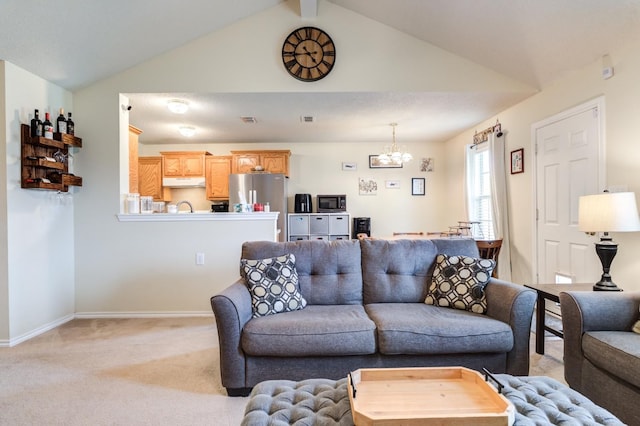 living room featuring vaulted ceiling with beams, light colored carpet, and a chandelier