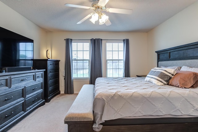 carpeted bedroom with ceiling fan and a textured ceiling