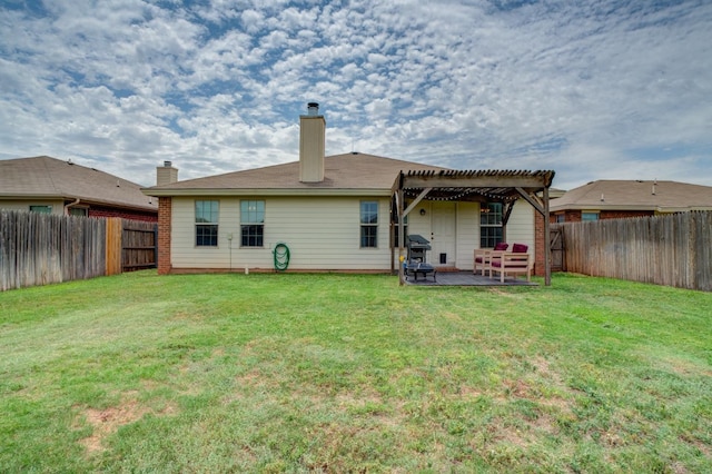 rear view of house featuring a yard, a pergola, and a patio area