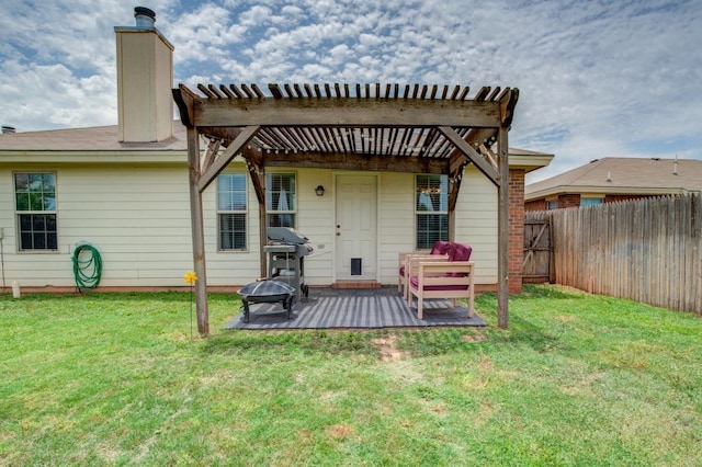 rear view of property featuring a yard, a pergola, and a fire pit