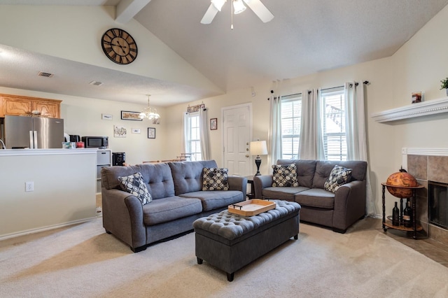 carpeted living room with beamed ceiling, high vaulted ceiling, ceiling fan with notable chandelier, and a tile fireplace