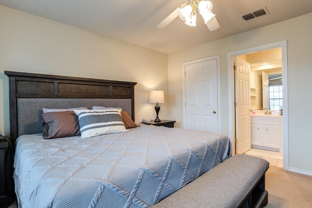 carpeted bedroom featuring ceiling fan, sink, and ensuite bath