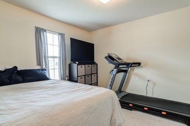 bedroom with light colored carpet and a textured ceiling