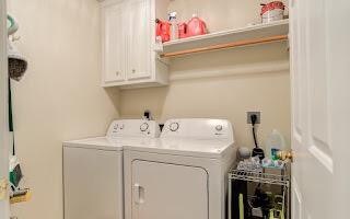 clothes washing area featuring cabinets and independent washer and dryer