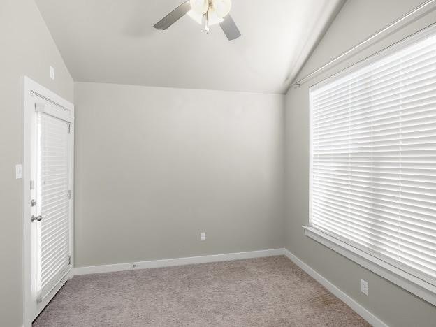 carpeted empty room featuring lofted ceiling and ceiling fan