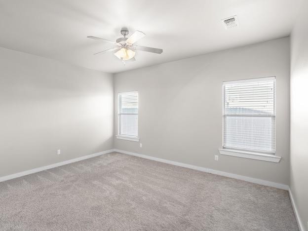 spare room featuring ceiling fan and light carpet