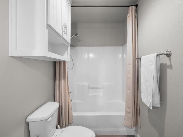 bathroom with toilet and shower / bath combo