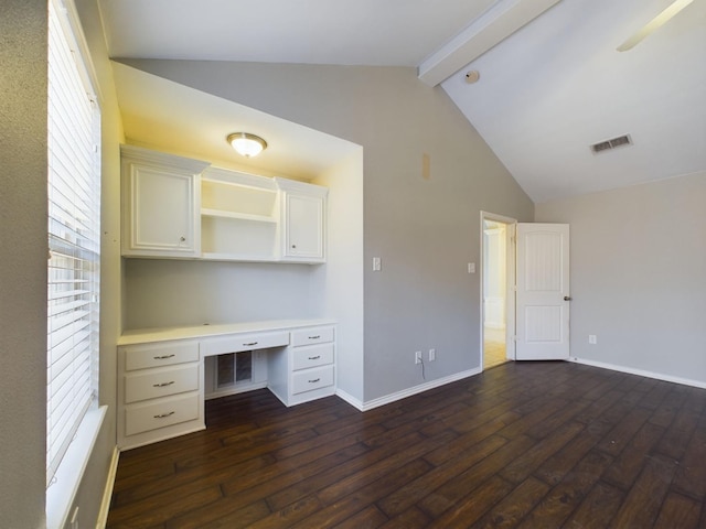 unfurnished office featuring beam ceiling, dark wood-type flooring, built in desk, and high vaulted ceiling