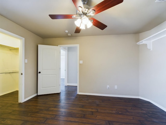 empty room with ceiling fan and dark hardwood / wood-style flooring