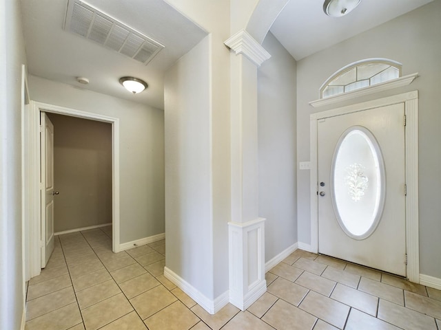 foyer entrance with light tile patterned floors and ornate columns