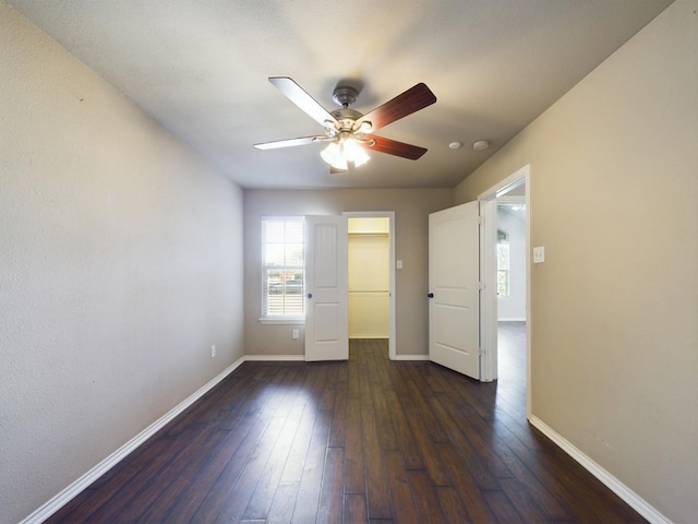 empty room with dark wood-type flooring and ceiling fan