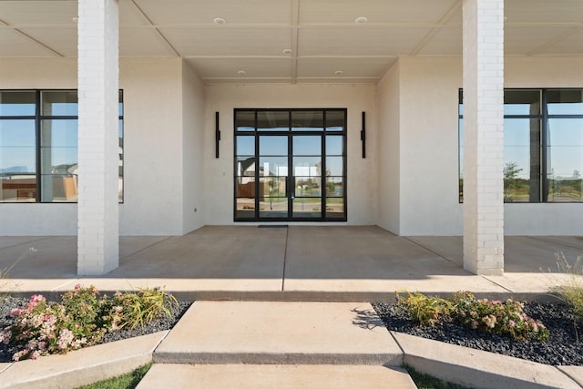 entrance to property with stucco siding and french doors