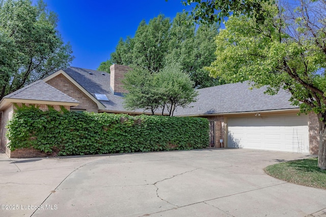 4420 87th St, Lubbock, TX 79424 - view of front of property with brick siding, driveway, an attached garage, a shingled roof, and a chimney