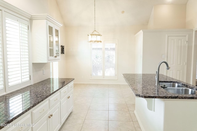 4420 87th St, Lubbock, TX 79424 - kitchen featuring a sink, white cabinetry, dark stone countertops, plenty of natural light, and vaulted ceiling
