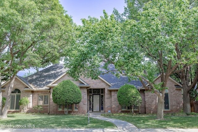 4420 87th St, Lubbock, TX 79424 - view of front of property with a front lawn, a shingled roof, and brick siding
