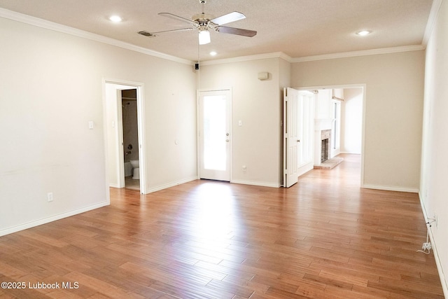 4420 87th St, Lubbock, TX 79424 - unfurnished room featuring a ceiling fan, light wood-type flooring, a brick fireplace, recessed lighting, and ornamental molding