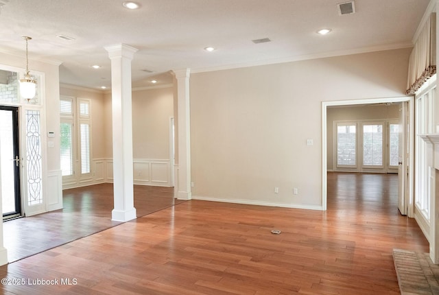 4420 87th St, Lubbock, TX 79424 - empty room featuring decorative columns, crown molding, light wood finished floors, a wainscoted wall, and a decorative wall
