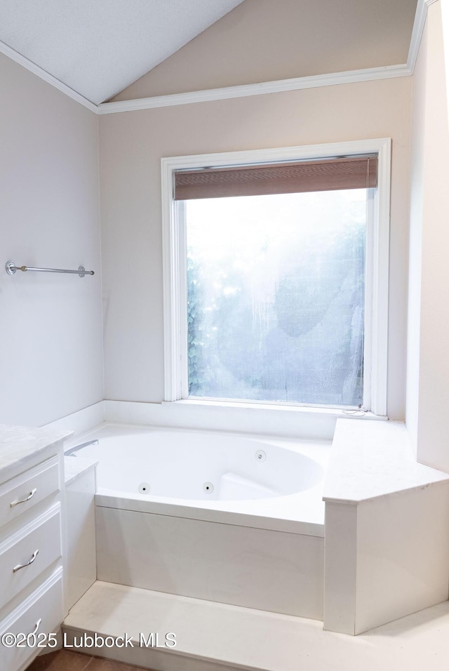 4420 87th St, Lubbock, TX 79424 - bathroom with lofted ceiling, a whirlpool tub, ornamental molding, and vanity