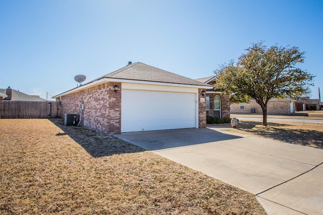 3602 Pontiac Ave, Lubbock, TX 79407 - view of side of property featuring fence, cooling unit, driveway, brick siding, and a garage