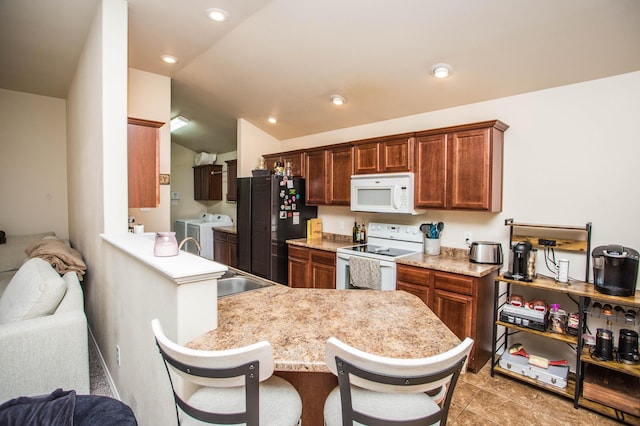3602 Pontiac Ave, Lubbock, TX 79407 - kitchen with vaulted ceiling, a kitchen bar, white appliances, independent washer and dryer, and light countertops