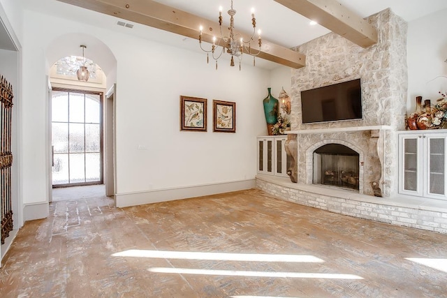 unfurnished living room featuring a fireplace, beamed ceiling, and a chandelier