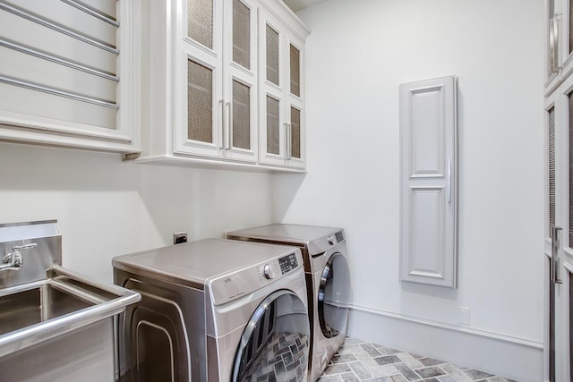 laundry room featuring cabinets, washer and clothes dryer, and sink