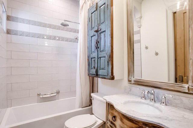 full bathroom featuring vanity, shower / bath combination with curtain, and toilet