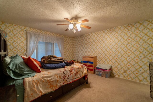 bedroom with ceiling fan, carpet flooring, and a textured ceiling