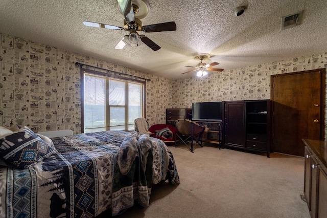 bedroom featuring ceiling fan, light carpet, and a textured ceiling