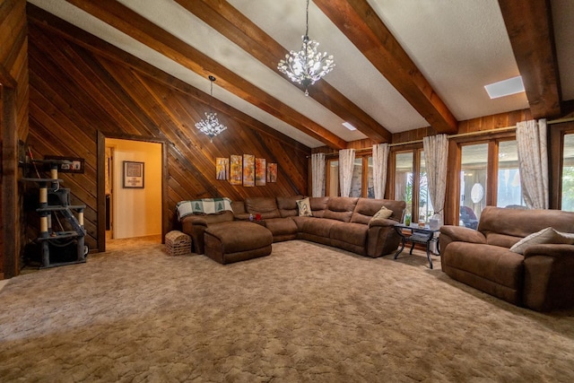 living room featuring lofted ceiling with beams, carpet flooring, a notable chandelier, and wood walls